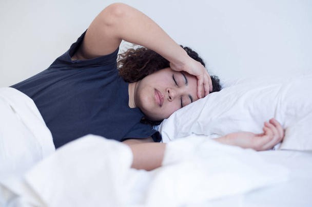 Больная черная женщина лежит в постели
 - Фото, изображение