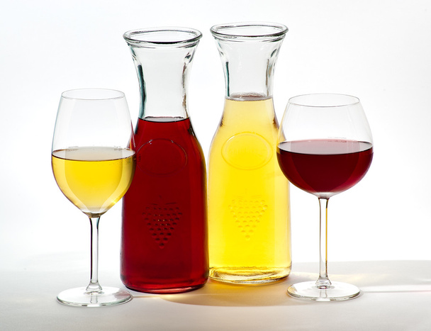 Two glasses of wine and two jugs of wine on a white background - Foto, Imagen
