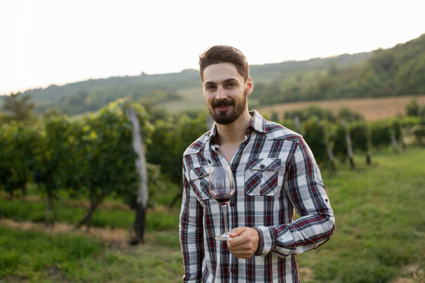 Winegrower tasting wine in vineyard - Foto, Imagen