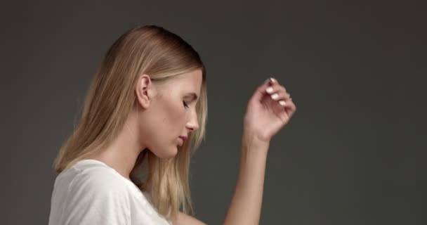 Atraktivní blondýnka mladá žena v bílé horní - Záběry, video
