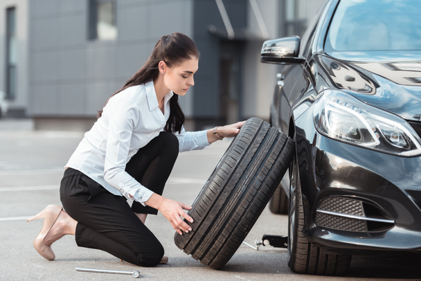 Femme changer de pneu de voiture
 - Photo, image