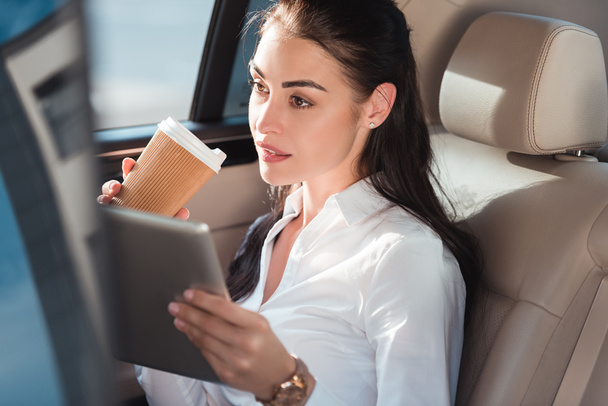 donna in auto con tablet digitale e caffè
 - Foto, immagini