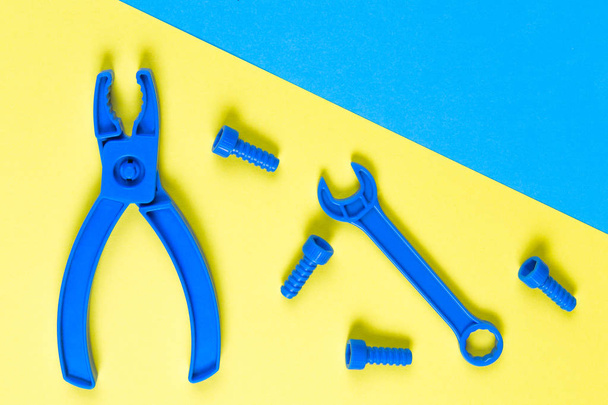 Giocattoli sfondo. Bambini costruzione giocattoli strumenti su sfondo blu e giallo. Vista dall'alto
 - Foto, immagini