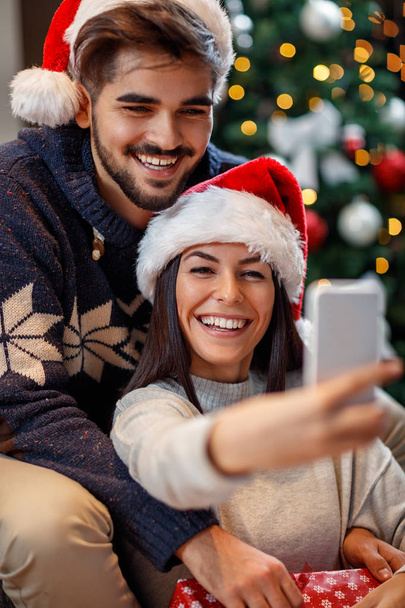 Man and woman taking selfie on Christmas eve - Φωτογραφία, εικόνα