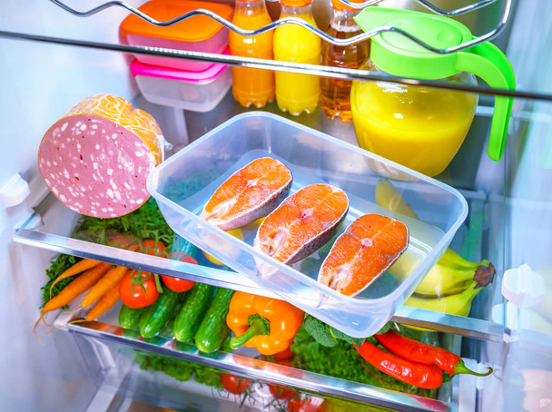 Raw Salmon steak in the open refrigerator - Фото, изображение