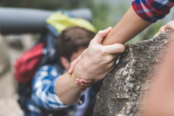 donna aiutare il fidanzato a scalare la roccia
 - Foto, immagini