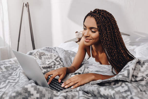 woman using laptop in bed  - Фото, изображение