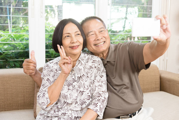 Happy senior Asian couple smiling at home - 写真・画像