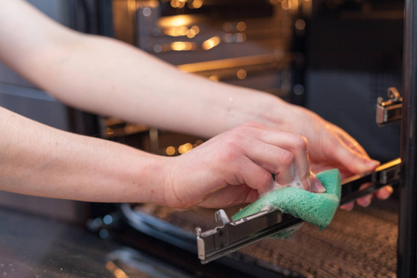Nainen kädet pullo puhdistusainetta metalli pesuallas keittiössä
 - Valokuva, kuva