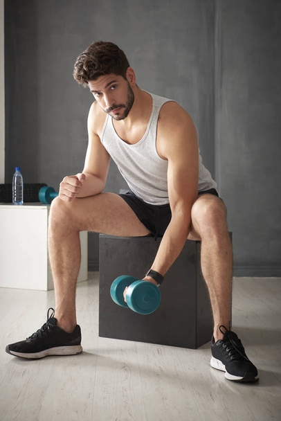 Young man using dumbbells - Foto, afbeelding