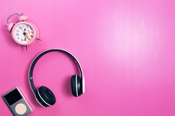 bezprzewodowe słuchawki i media player, różowy budzik  - Zdjęcie, obraz