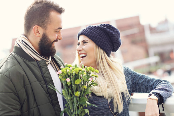 街でデートの花と若いカップルを示す画像 - 写真・画像