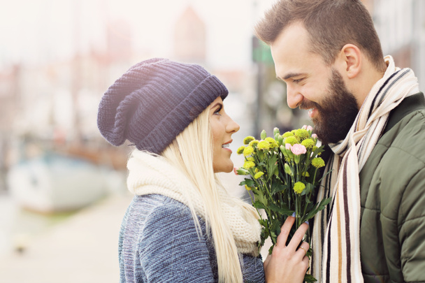 街でデートの花と若いカップルを示す画像 - 写真・画像