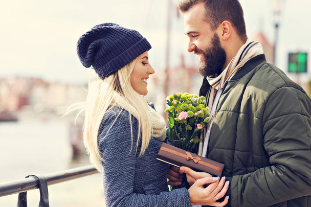 Imagem mostrando jovem casal com flores namoro na cidade
 - Foto, Imagem