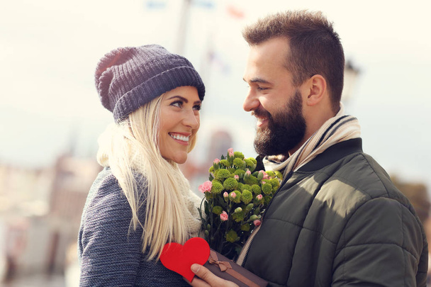 Picture showing young couple with flowers dating in the city - Foto, Imagem