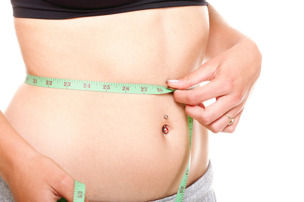 Woman slim stomach with measuring tape around it - Foto, Imagem
