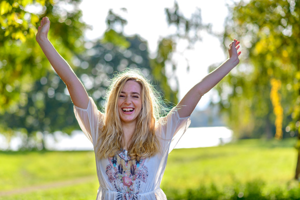 Young happy woman raising hands outdoors - Photo, Image