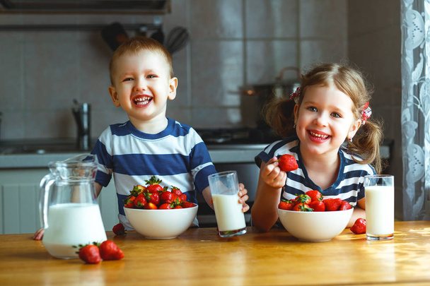 Enfants heureux frère et sœur manger des fraises avec du lait
 - Photo, image