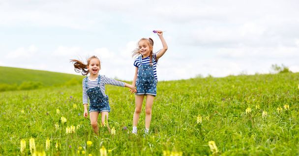 onnellisia lapsia kaksoset sisaret hyppäävät ja nauravat kesällä
 - Valokuva, kuva