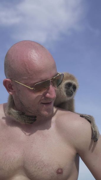 Man with monkey on the beach - Photo, Image