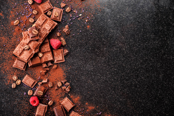 Kırık mermer üzerinde çikolata parçaları ve kakao tozu.  - Fotoğraf, Görsel