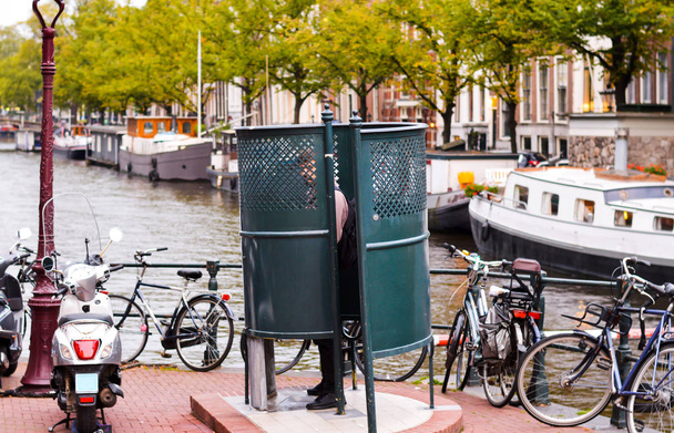 Hombre orinando en Amsterdam en un urinario público
  - Foto, imagen