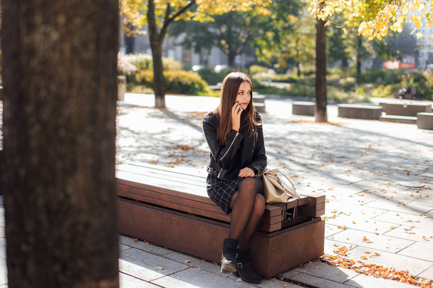 Young girl talk on the phone at park background - 写真・画像