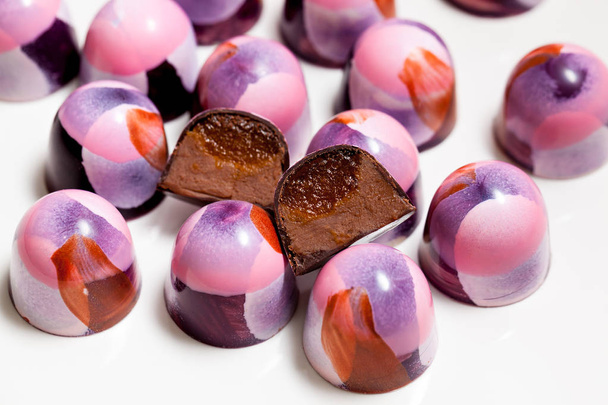 Closeup of chocolate hand painted candy bonbons on a white background. - Foto, Imagem