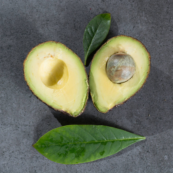 Ripe avocado close up on gray concrete background, diet and healthy food concept, copy space top view - Photo, Image