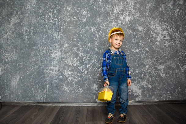 the boy in yellow hard hat and a yellow tool box - 写真・画像