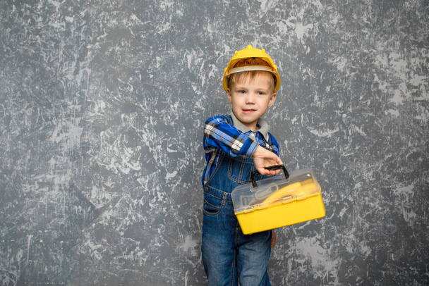 the boy in yellow hard hat and a yellow tool box - Фото, зображення