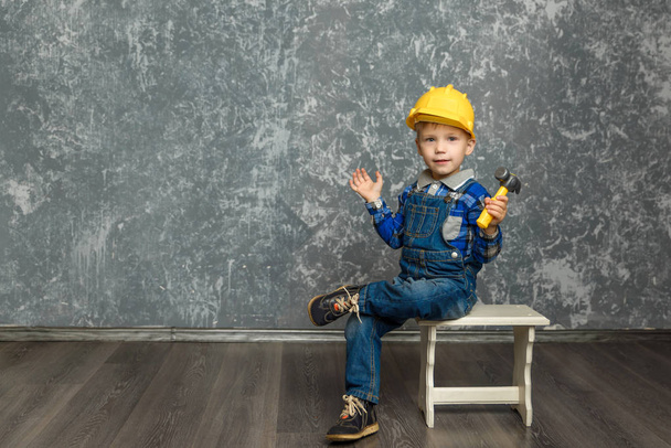 the boy in yellow hard hat holding a hammer - Photo, image