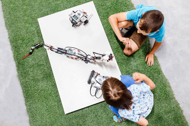 Two young boys playing with robots, educational and playing concept - Photo, Image