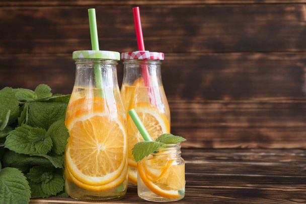 bottles of water with citrus (orange and lemon) on a wooden tabl - Foto, Imagem