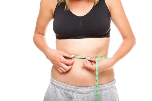 Woman slim stomach with measuring tape around it - Photo, Image