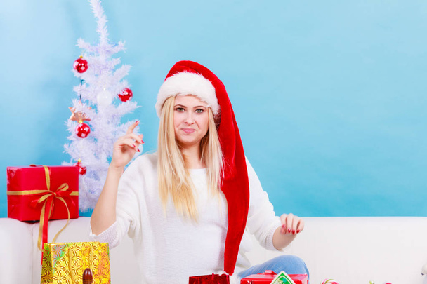 Woman in Santa hat preparing christmas gifts - Foto, Bild