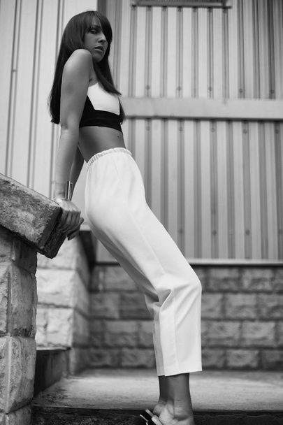 Fashion black and white outdoor portrait of stylish brunette woman on the street - Valokuva, kuva