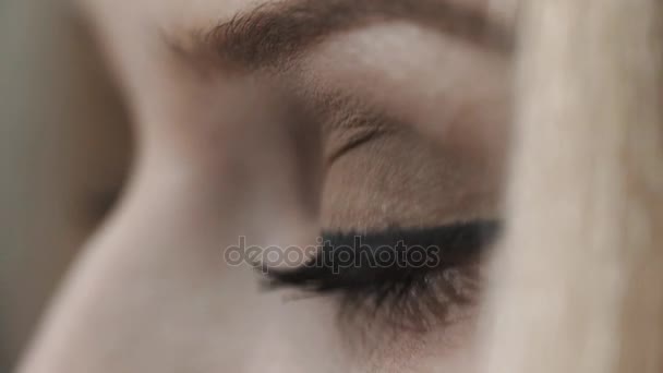 Genç kadın gri gözleri yanıp sönüyor. Siyah rimel ve göz kalemi - Video, Çekim