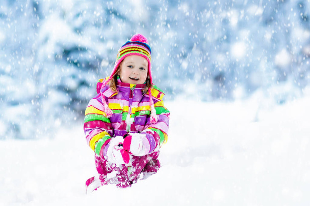 Enfant jouant avec la neige en hiver. Enfants en plein air
. - Photo, image