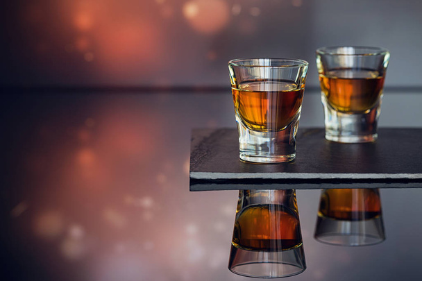 Cognac or liqueur, coffee beans and spices on a glass table. - Photo, image