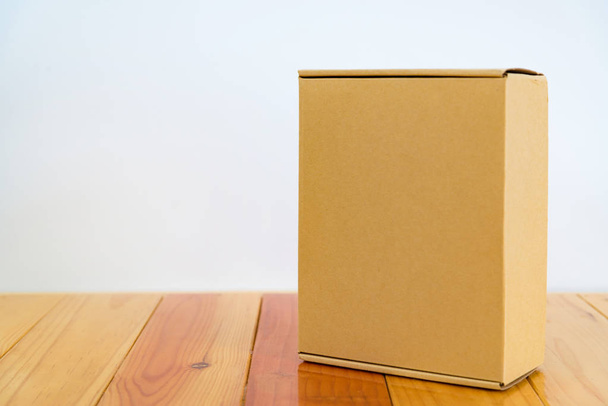 Empty brown cardboard box on wooden table with copy space. - Foto, Bild
