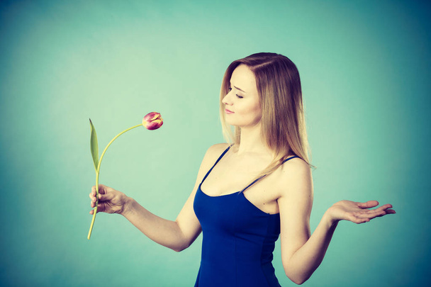 Shot on blue of woman holding tulip - Φωτογραφία, εικόνα