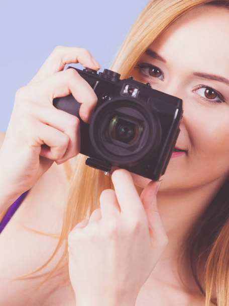 Blonde vrouw met camera op blauw - Foto, afbeelding