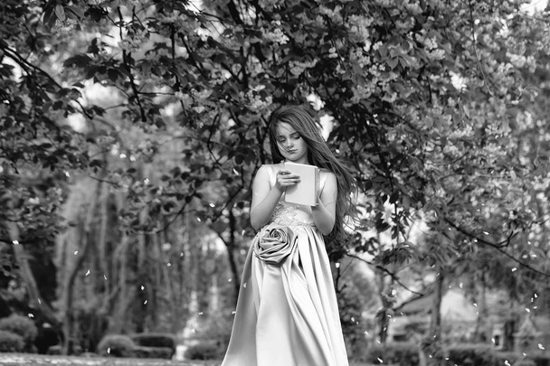 Girl in dress with notebook and pen in garden - Fotografie, Obrázek
