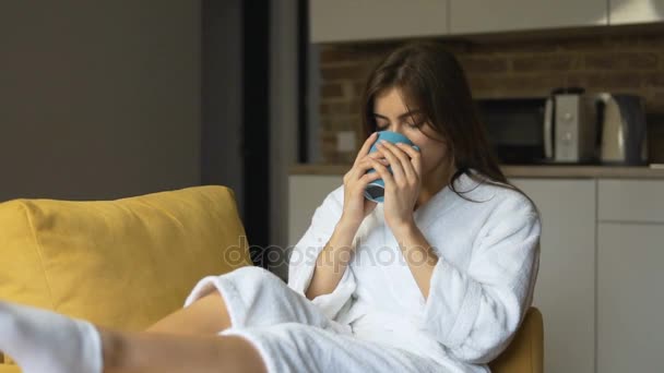 Girl Enjoys Coffee in Armchair - Πλάνα, βίντεο