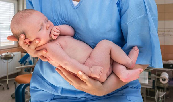 Лікар тримає красиву новонароджену дитину
 - Фото, зображення