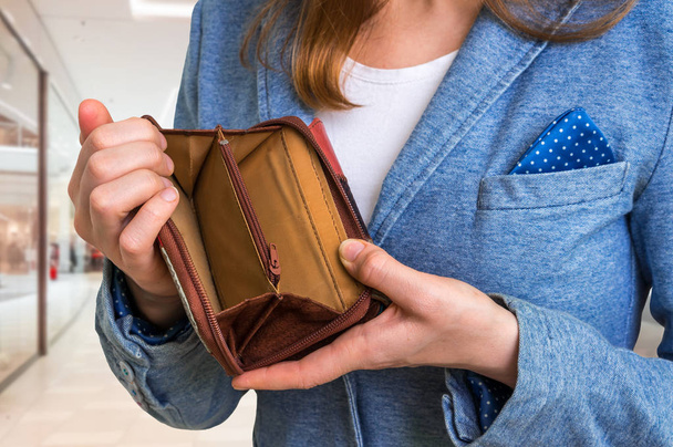 Γυναίκα που κρατά ένα άδειο πορτοφόλι σε εμπορικό κέντρο - Φωτογραφία, εικόνα