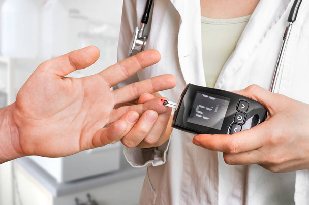 Doctor checking blood sugar level with glucometer - Foto, Imagen