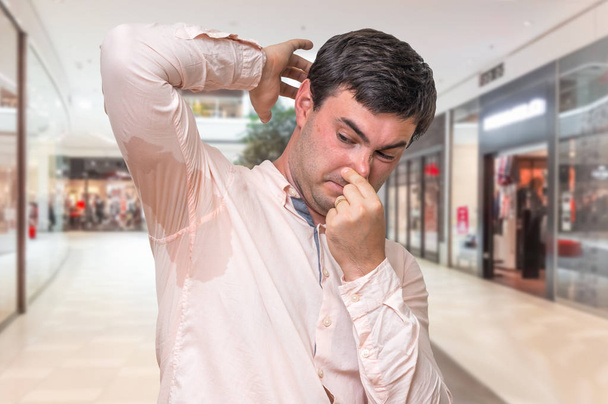 Άνθρωπος εφίδρωση κάτω από τη μασχάλη στο εμπορικό κέντρο - Φωτογραφία, εικόνα