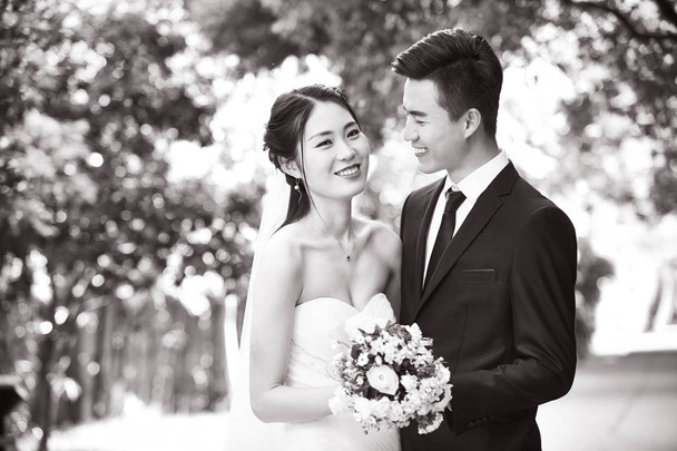 Außenporträt eines frisch verheirateten asiatischen Paares - Foto, Bild